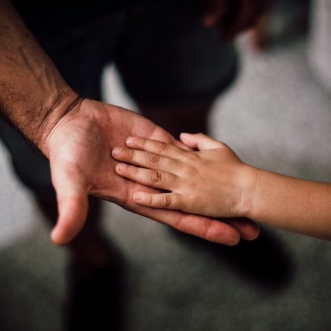 Adult hand with Child's Hand