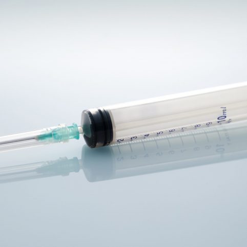 Medical syringe and needle with reflection image.